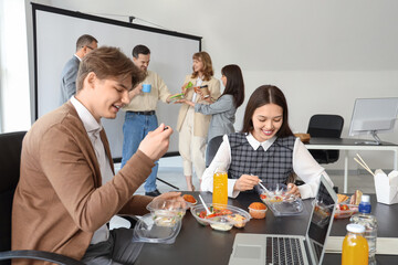 Business people having lunch at table in office