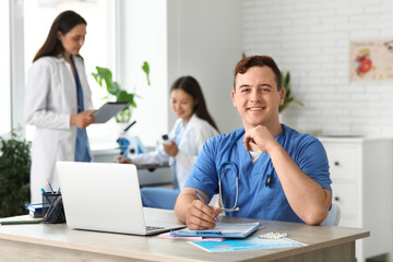 Male doctor working at table in clinic