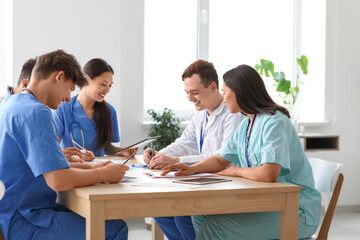 Young doctors working at table in clinic