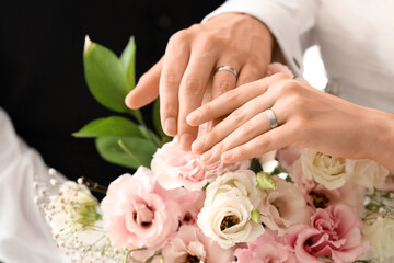 Young couple with rings and flowers on their wedding day, closeup