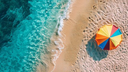 Obraz premium Aerial View of Vibrant Umbrella on Sandy Beach with Turquoise Ocean Waves