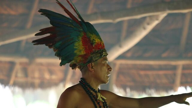 CloseUp of Wayuri Tribe Member with Feather Crown During Ceremony in Ecuadorian Amazon Rainforest