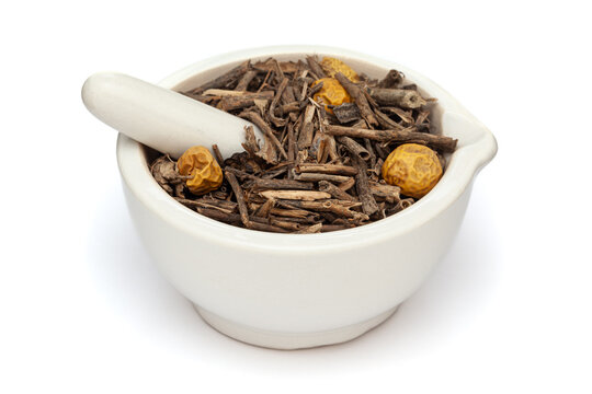 Close-up of Dry Organic Yellow - Berried Nightshade or Kantakari (Solanum virginianum) herb, in white ceramic mortar and pestle, isolated on a white background.