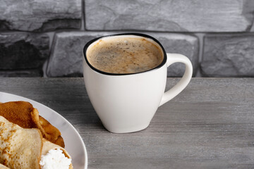 Cup of coffee with pancakes for breakfast