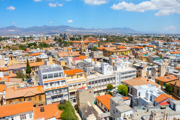 Obraz premium Nicosia City view with many buildings and a mountain in the background. Nicosia urban landscape featuring a multitude of buildings in Cyprus