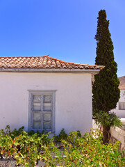 White mediterranean house, rooftop, window, cypress and arbor pergola in a sunny day with clear sky 