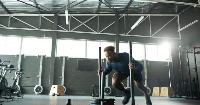 Man, bodybuilder and pushing weight sled at gym for fitness exercise, muscle strength and power performance. Athlete, male person and bodybuilding training, equipment and energy of workout challenge