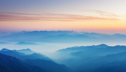 A panoramic view of a mountain range at dawn, with layers of peaks fading into the distance,