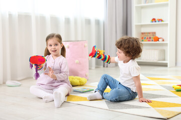 Cute little children playing with funny sock puppets in kindergarten