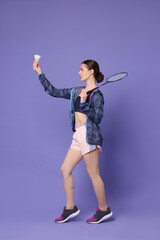 Young woman with badminton racket and shuttlecock on purple background