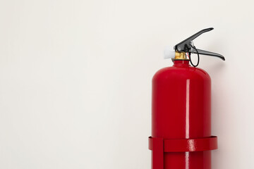 Fire extinguisher on light background, space for text
