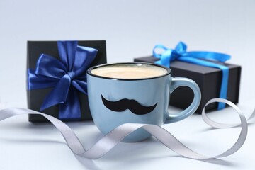 Happy Father's Day. Cup of coffee with funny moustache and gift boxes on light background