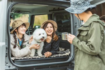 愛犬・ペットと一緒にキャンプ・デイキャンプ・ドライブするアウトドアファッションの女性・友達・親友
