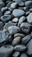 Close-up of smooth black pebbles, textured background. Nature and tranquility concept