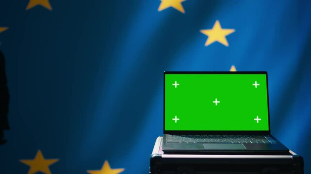 European Union agency using green screen laptop to protect against mass propaganda affecting elections. EU security service engaging in psychological operations using mockup device, close up, camera B