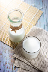 Top view glass and bottle of tasty milk on wooden table