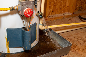 Water gushing out of water heater drain, into drain pan.