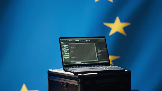 Laptop in European Union command center used by counterterrorism department to run security protocols against propaganda bots trying to destabilize democracy, isolated over EU flag, camera A