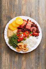 Brazilian feijoada, traditional food from Brazil cuisine, on dish, over rustic wooden table