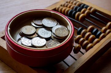 Russian currency, coins lie next to hand abacus on a wooden surface