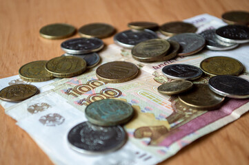 Russian currency, coins, banknotes lie on a wooden surface