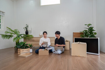 Young Couple Unpacking Boxes in Their New Home with Modern Interior and Green Plants