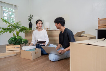 Young Couple Unpacking Boxes in Their New Home, Smiling and Organizing Belongings in a Bright Modern Living Room