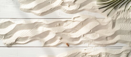 Sand on a white wooden surface with a summer theme. Overhead view with space for text.