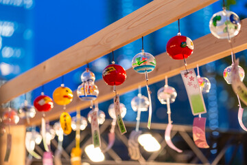 夕暮れの光の中で風に踊る色とりどりの風鈴（2023年7月）