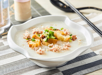 Minced beef porridge topping with spring onion served in bowl isolated on napkin side view of chinese food