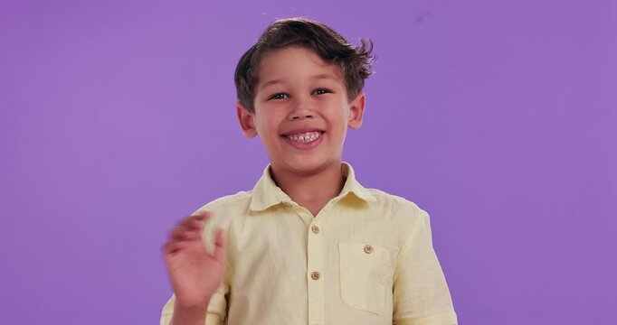 Happy boy, child and wave with greeting in studio for introduction, hello or bye on a purple background. Portrait of male person or friendly little kid with smile for presentation, signal or gesture