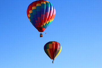 Obraz premium Dawn ascent of vibrant balloons over water