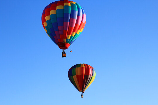 Dawn ascent of vibrant balloons over water