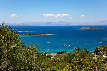 Scenic coastal view with clear cyan sea, fishing boats and islands