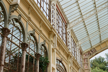 Ornate greenhouse with arched windows and ironwork