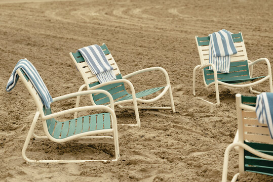 Beach chairs with striped towels on sandy beach