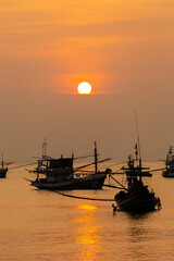 Fototapeta premium Fishing Wood boat on peaceful calm relaxing on the water and dramatic clouds at Sunset
