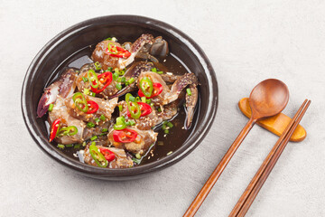  A food made by boiling ingredients such as onions and peppers, then pouring the cooled soy sauce over prepared crabs several times and allowing them to age.
