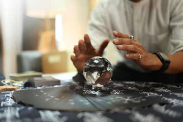 Mysterious fortune teller predicting future with crystal ball on desk. Astrologists, forecasting...