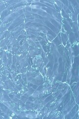 Blue water with ripples on the surface. Defocus blurred transparent blue colored clear calm water surface texture with splashes and bubbles. Water waves with shining pattern texture background.	