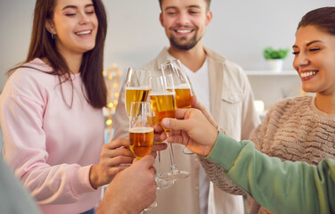 A group of happy young people standing toasting, close-up. Friends raise glasses of wine. Concept to celebrate a holiday, a joyful event. Alcoholic drinks for parties, weekends, leisure