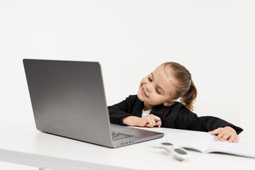 Close-up of a young business girl studying on a laptop on an isolated white background. Concept of modern technology, business and education.