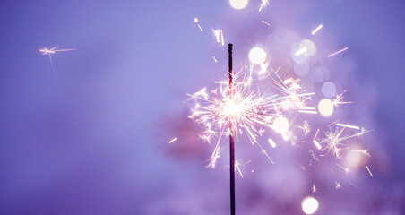 Beautiful sparklers made of sparklers on a purple background of New Year's bokeh, Christmas mood, glitter, holiday background. Happy New Year! Happy holiday!
