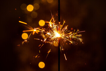 Beautiful sparklers from sparklers on a brown background New Year's bokeh, Christmas mood, glitter,...