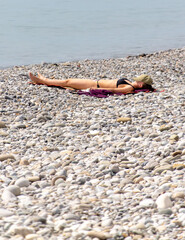 A woman sunbathes on a sunbed on the seashore