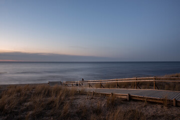 Obraz premium wooden path to the beautiful sunset beach