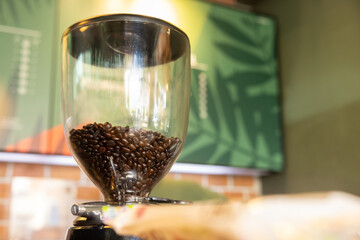 A coffee grinder with a glass container full of coffee beans