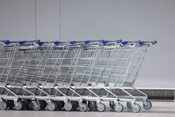 A row of shopping carts are lined up against a wall