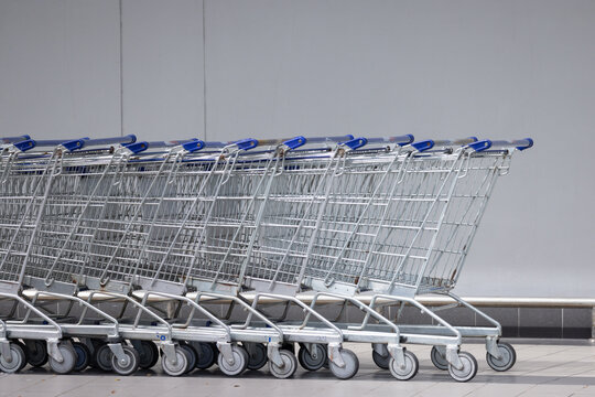 A row of shopping carts are lined up against a wall