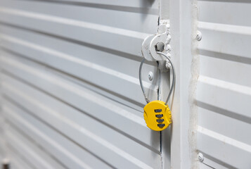 A yellow lock with a keyhole on a white door